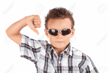 a young boy wearing sunglasses giving a thumbs down