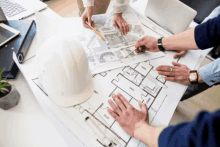 a group of people are looking at a blueprint of a building