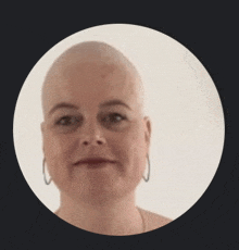 a woman with a shaved head and hoop earrings is in a circle .