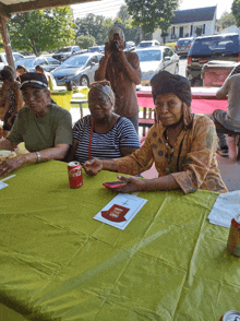 a woman sitting at a table with a can of coca cola on it