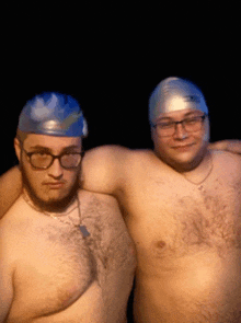 two men wearing swim caps and glasses are posing for a photo