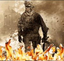 a soldier is standing in the middle of a fire holding a gun .