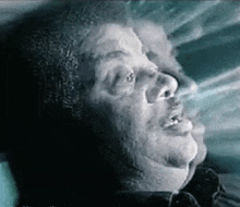 a close up of a man 's face with smoke coming out of his eyes .