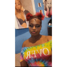 a woman wearing a tie dye off the shoulder top with the word oaee on it