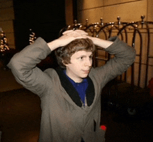 a man with his hands on his head stands in front of a cart