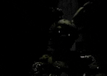 a silhouette of a rabbit in a dark room with balloons .