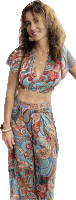 a woman in a paisley top and pants is smiling