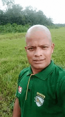 a bald man is taking a selfie in a field .