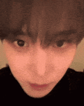 a close up of a person 's face with a black turtleneck .