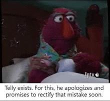 elmo from sesame street is sitting on a bed with a remote control .