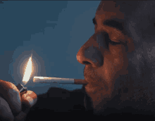 a man lighting a cigarette with a lighter in his hand