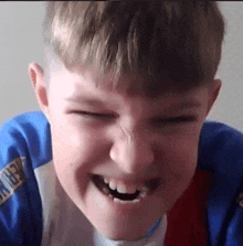 a young boy with a missing tooth is making a funny face with his mouth open .