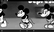 a black and white photo of three mickey mouses on a phone screen