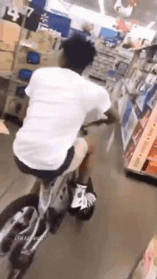 a man is riding a bike in a store while wearing roller skates .