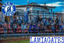 a group of people standing in front of a fence with the name lamiagate3 on the bottom