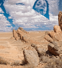 a desert landscape with rocks and mountains in the distance