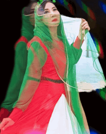 a woman in a red and green dress has a green veil on her face