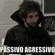 a man sitting at a table with a glass of wine and the word passivo aggressivo written on it