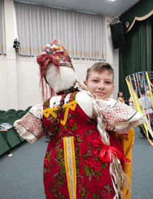 a boy holding a doll in a traditional costume