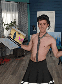 a shirtless man is holding a laptop with a picture of a man on it