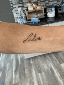 a woman has a tattoo on her arm that says ' livia '