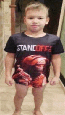 a young boy is standing in a hallway wearing a t-shirt with a soldier on it .