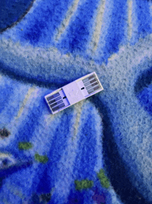 a small item on a blue blanket with the letter e on it