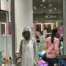 a woman in a shark costume is standing in front of a store window with the word morgan on it