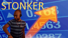 a man wearing headphones stands in front of a screen that says stonker