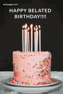 a birthday cake with candles and sprinkles on it is on a plate on a table .