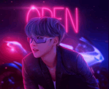 a neon sign that says open is behind a man