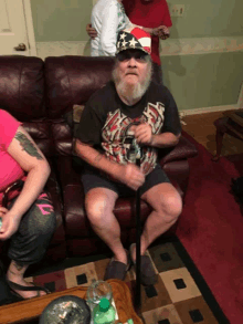 a man sitting on a couch with a cane wearing a patriotic hat