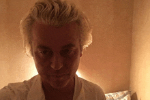 a man with blonde hair looks at the camera