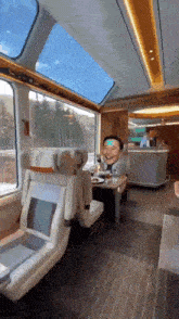 a man is sitting at a table on a train with a mask on his head .