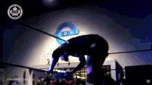 a man is wrestling in front of a smash zone sign