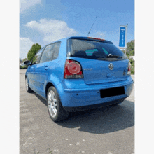 a blue volkswagen polo is parked in front of a sign that says ' allianz '