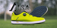 a pair of yellow toa shoes sitting on a grassy field