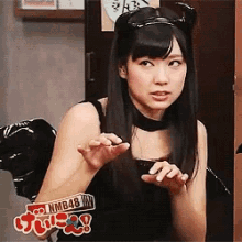 a woman in a cat costume is wearing a nmb48 sticker on her wrist