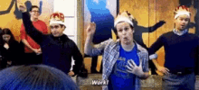 a group of men wearing crowns are dancing in a room and one man says work .