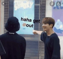 two boys are pointing at a sign that says " shooky "