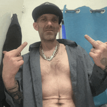 a shirtless man wearing a hat and a necklace with the letter a on it