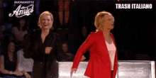 two women in red jackets are dancing on a stage in front of a trash italiano logo .