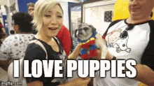 a woman and a man holding pug puppies with a caption that says i love puppies