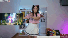 a girl is dancing in front of a screen that says 738/770 on it