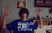 a man wearing a blue shirt that says absolute cinema on it