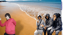 a group of people standing on a beach with the words photo.com on the bottom left