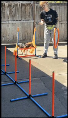 a woman in a t-shirt that says ' i 'm a dog ' is playing with a dog