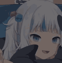 a girl with white hair and blue eyes is laying on a bed .