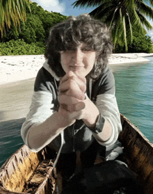 a person in a boat on a beach with palm trees