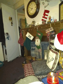 a clock hangs above a mantle with christmas stockings hanging on it